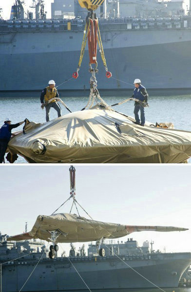 資料圖：美國海軍人員將一架X-47B無人空戰(zhàn)系統(tǒng)驗證機運送到杜魯門號航母上。