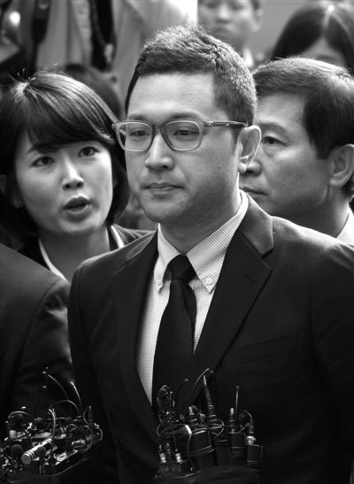 25日，韓國總統李明博長子李時炯（前）前往韓特別檢察官小組所在地接受調查。新華社發