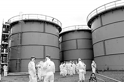 3月1日，一群日本記者在福島第一核電站內的污水儲藏罐前采訪。日益增多的核污水是當前事故搶修工作面臨的主要難題之一。資料圖片