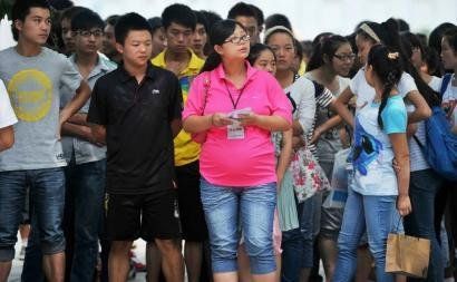 6月7日，雅安天全中學(xué)的呂莎莎老師(中)在考場(chǎng)外等待自己的學(xué)生出來。