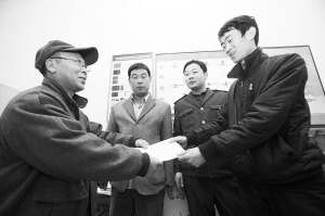 劉大爺莊重地將感謝信交到車隊隊長的手中。本報記者 李志華 攝 劉大爺莊重地將感謝信交到車隊隊長的手中。本報記者 李志華 攝