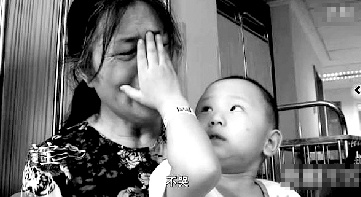 視頻中“小中寶”看到奶奶為他掉眼淚，就伸手為奶奶抹去眼淚。視頻截圖 