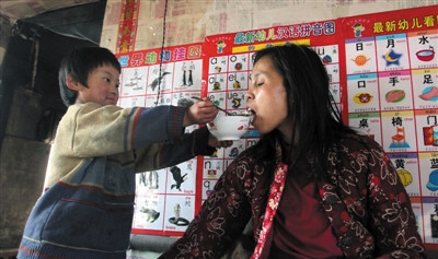 小孫悅為臥床的母親喂飯。