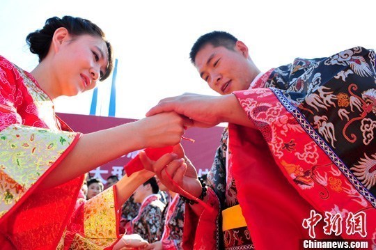 9月1日，一場別開生面的“重溫漢唐風(fēng)”漢式集體婚禮在泉城濟(jì)南舉行，72名新人身著傳統(tǒng)漢服喜結(jié)良緣，并在許愿墻上許下“千年共枕眠，一世永相愛”心愿。圖為新人解纓結(jié)發(fā)。中新社發(fā) 張勇 攝