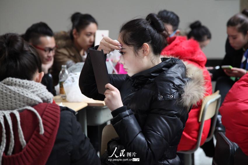 2014年2月17日，山東濱州，藝考候考考生在濱州學院報名點化妝。