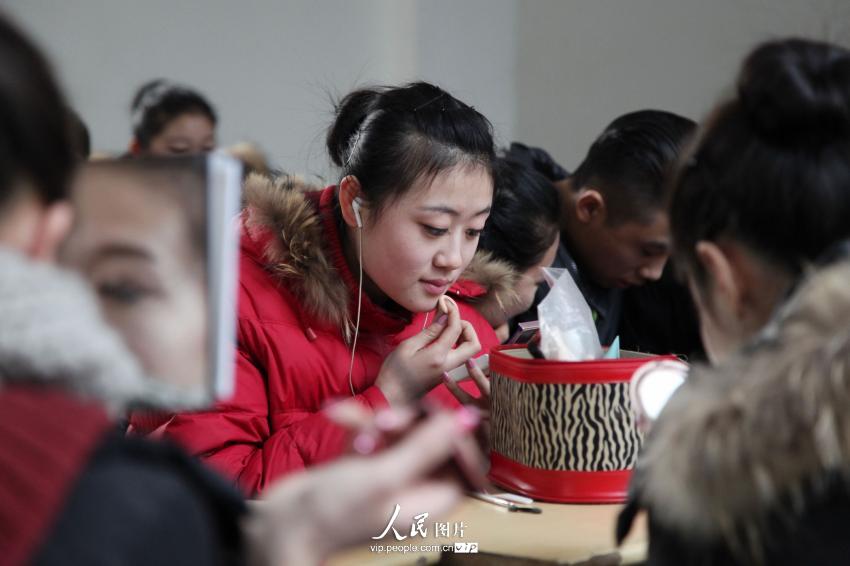 2014年2月17日，山東濱州，藝考候考考生在濱州學院報名點化妝。