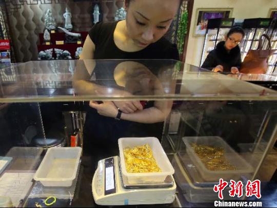 金店工作人員正在稱重?！?jiān)啤z