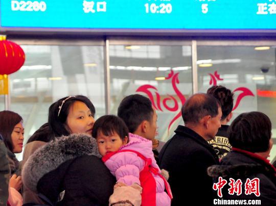 一名兒童在母親的懷抱中候車。 吳正琪 攝